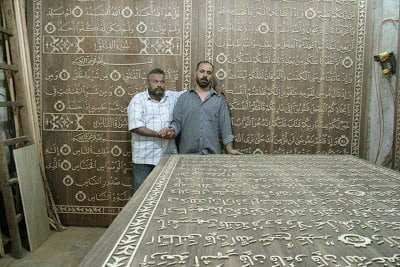 خطاط سوري و نجار مصري يعملان علي أكبر نسخة من القرآن الكريم في العالم